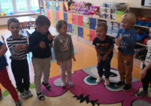 zdjęcie 5 dzieci stojących na dywanie